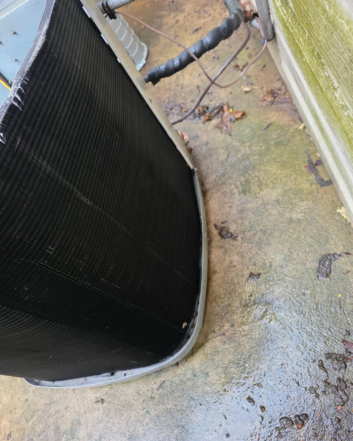 Same outdoor AC condenser coil after a full cleaning — fins clear of debris and back in spec